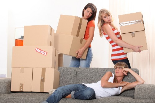 Local movers navigating stairs in a Highbury flat during a relocation